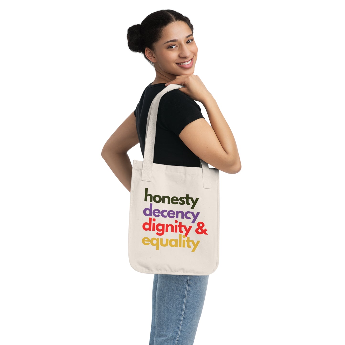 Person holding a tote bag with 'honesty decency dignity & equality' text on a white background