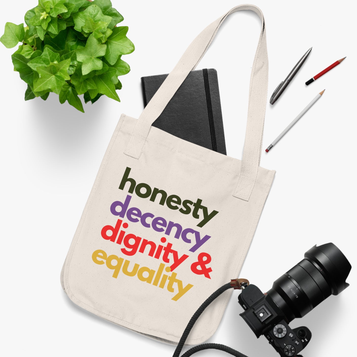 Tote bag with motivational text on a white surface with stationery items